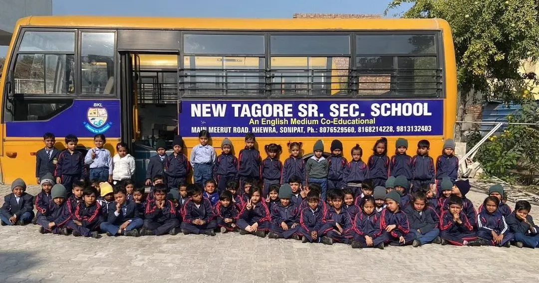 Students of New Tagore Sr. Sec. School gathered at the school gate in Khewra, with the school buses behind them